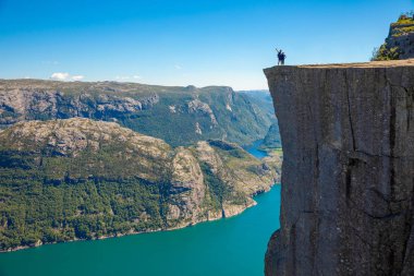 Preikestolen üzerinde duran ve fjerd, Preikestolen - Norveç dağlar, ünlü cliff üzerinde seyir uzun yürüyüşe çıkan kimse