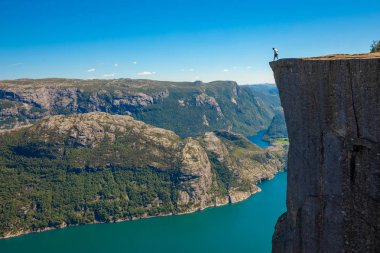 Preikestolen üzerinde duran ve fjerd, Preikestolen - Norveç dağlar, ünlü cliff üzerinde seyir uzun yürüyüşe çıkan kimse