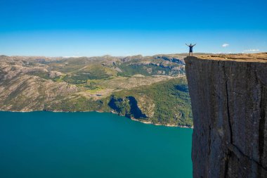 Preikestolen üzerinde duran ve fjerd, Preikestolen - Norveç dağlar, ünlü cliff üzerinde seyir uzun yürüyüşe çıkan kimse