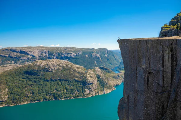 Hiker standing on Preikestolen and looking on the fjerd, Preikestolen - famous cliff at the Norwegian mountains — Stock Photo, Image