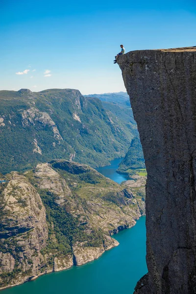 Hiker standing on Preikestolen and looking on the fjerd, Preikestolen - famous cliff at the Norwegian mountains — Stock Photo, Image