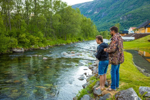 Roldal, Norway - 26.06.2018: Father and son are fishermans fly fishing in river near Rodal town, Norway — Stock Photo, Image