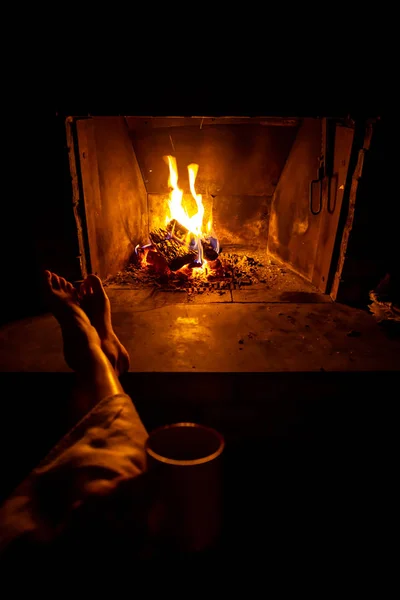 Genç kadının çıplak bacaklar şömine ateş açın tarafından ısıtılır — Stok fotoğraf