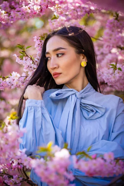 Çiçeklenme içinde güzel genç Asyalı kadın kiraz çiçekleri Bahçe