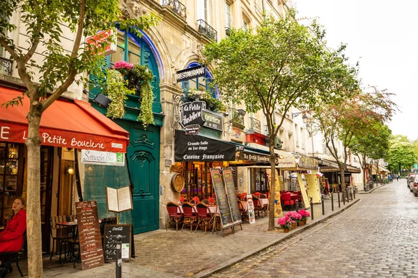 Paris, Fransa - 24.04.2019: Latin Mahallesi. Paris'te eski geleneksel Paris evleri ve kafe arasında Paris Dar sokak, Fransa