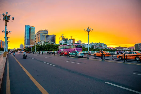 Sanya, Hainan, Cina - 26.06.2019: Paesaggio urbano di Sanya con strade trafficate e edifici nel tempo del tramonto, provincia di Hainan, Cina — Foto Stock