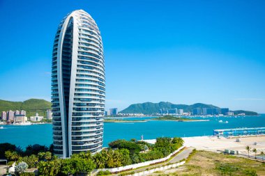 Sanya, Hainan Island, China - 22.06.2019: Close view of artificial Phoenix island with its famous skyscrappers in Sanya bay, Hainan Island, China clipart