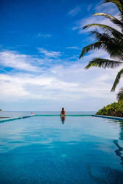 Frau entspannen im Infinity-Pool mit Meerblick, Urlaub in den Tropen — Stockfoto