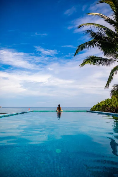 Frau entspannen im Infinity-Pool mit Meerblick, Urlaub in den Tropen — Stockfoto