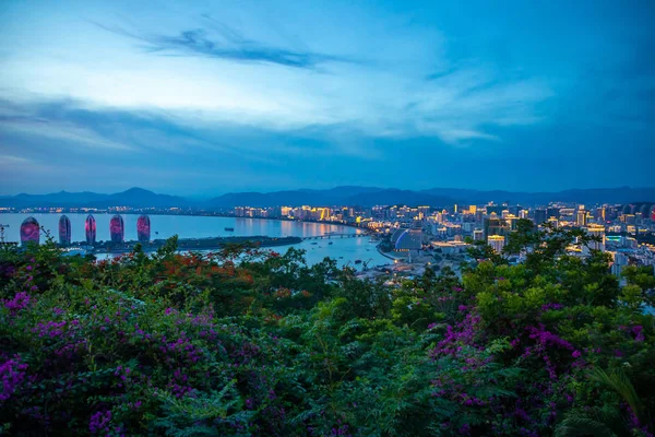 Sanya, Hainan, China - 7.07.2019: Vista nocturna de la isla de Phoenix y la ciudad de Sanya iluminada con luces de la ciudad. Vista desde el Parque Luhuitou en la isla de Hainan, China —  Fotos de Stock