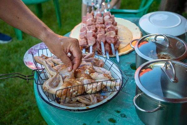 Barbeküde şiş kebap yapmak için salamura edilmiş alüminyum bir şişe et iğneleyen bir adamın eline yakın plan. — Stok fotoğraf