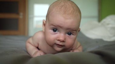 Üç aylık beyaz, şirin bir kız bebek. Gri battaniyeli. Evde.