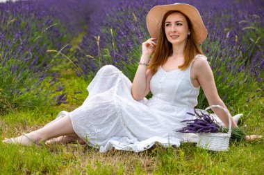 Çek Cumhuriyeti 'nde lavanta tarlasında buketle yürüyen bir kadın