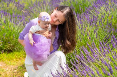 Anne, küçük kızıyla Çek Cumhuriyeti 'nde elinde bir demet lavanta tutarak yürüyor.