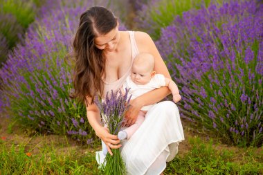 Anne, küçük kızıyla Çek Cumhuriyeti 'nde elinde bir demet lavanta tutarak yürüyor.