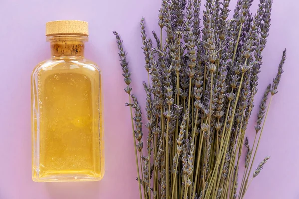 Ätherisches Lavendelöl Eine Flasche Und Lavendelstrauß Auf Violettem Hintergrund — Stockfoto