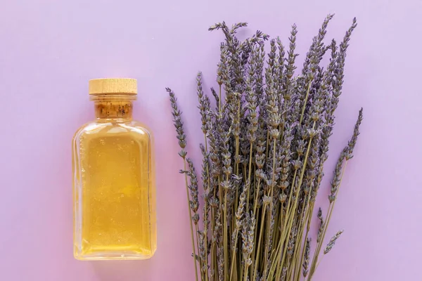 Ätherisches Lavendelöl Eine Flasche Und Lavendelstrauß Auf Violettem Hintergrund — Stockfoto