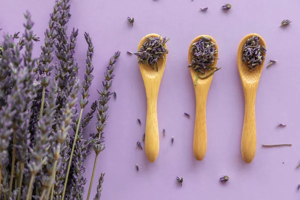 Trockene Lavendelblüte Holzlöffel Und Lavendelstrauß Auf Violettem Papier Hintergrund — Stockfoto