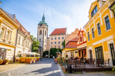 Melnik, Çek Cumhuriyeti - 29.07.2020: Aziz Peter ve Paul Kilisesi 'nin kafe ve saat kulesiyle gün batımında eski cadde, Çek Cumhuriyeti