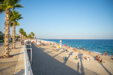 Antalya, Türkiye - 2.09.2020: Günbatımında Konyaalti kumsalı ve Taurus dağları, Antalya, Türkiye