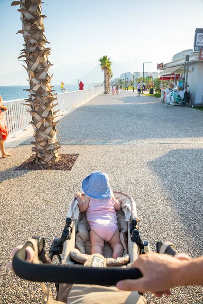 Antalya, Turquía - 2.09.2020: Caminar con el bebé en la playa de arena Konyaalti y las montañas de Tauro en la luz del atardecer, Antalya, Turquía — Foto de Stock