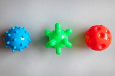 Gri arka planda virüs olarak renkli plastik toplar, tıbbi konsept