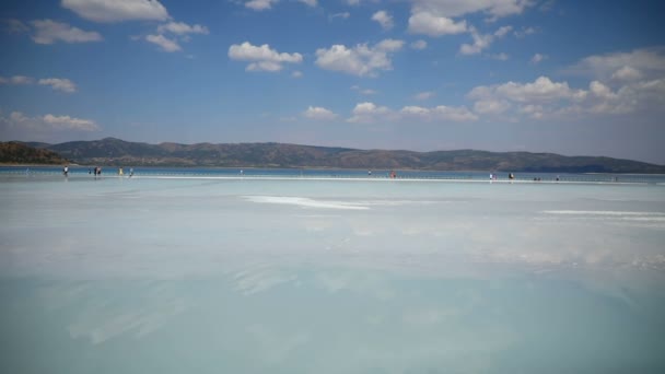 Οι παραθεριστές κάνουν ηλιοθεραπεία στην παραλία Salda Lake, Burdur, Τουρκία — Αρχείο Βίντεο