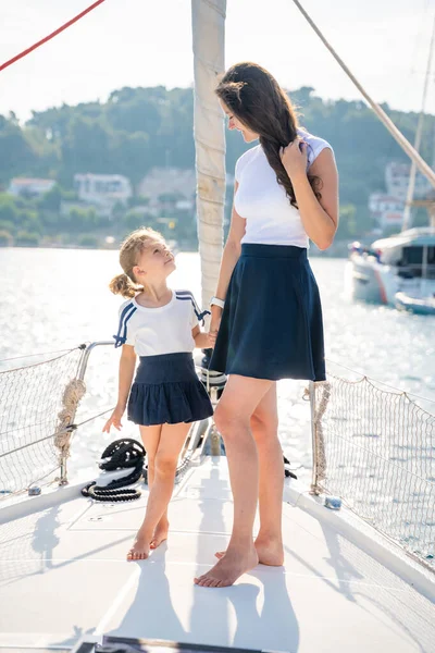 Anne ve kızı yelkenli bir yatın pruvasında birlikte vakit geçiriyorlar. Aile bağları, deniz maceraları ve huzurlu bir seyahat tarzı. Yüksek kalite fotoğraf