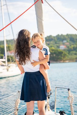 Anne ve kızı yelkenli bir yatın pruvasında birlikte vakit geçiriyorlar. Aile bağları, deniz maceraları ve huzurlu bir seyahat tarzı. Yüksek kalite fotoğraf