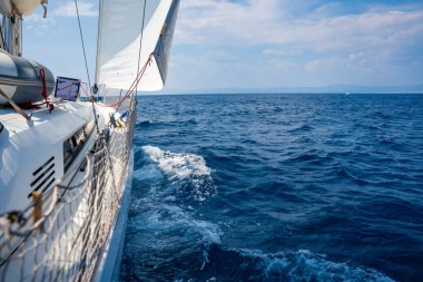 Denizi yarıp geçen bir yatın yanında Hırvatistan yakınlarında yelkenler açılıyor. Hareket, özgürlük, yelkencilik yaşam tarzı ve açık denizde macera. Yüksek kalite fotoğraf