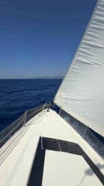 Denizi boydan boya geçen yelkenli bir yatın pruvası. Hırvatistan yakınlarında yelkenler tamamen açık. Özgürlük, hareket, temiz enerji ve açık denizde yavaş yolculuk. Yüksek kalite 4k görüntü