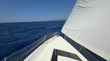 Denizi boydan boya geçen yelkenli bir yatın pruvası. Hırvatistan yakınlarında yelkenler tamamen açık. Özgürlük, hareket, temiz enerji ve açık denizde yavaş yolculuk. Yüksek kalite 4k görüntü