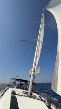 Lastovo, Hırvatistan - 14 Haziran 2025: Hırvatistan yakınlarındaki bir yatın pruvasından görülen rüzgar dolu beyaz yelkenliler. Özgürlük, temiz enerji, macera ve açık denizde dikkatli bir yolculuk.. 