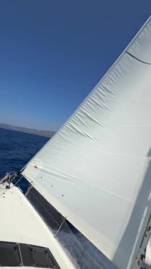 Lastovo, Hırvatistan - 14 Haziran 2025: Hırvatistan yakınlarındaki bir yatın pruvasından görülen rüzgar dolu beyaz yelkenliler. Özgürlük, temiz enerji, macera ve açık denizde dikkatli bir yolculuk.. 