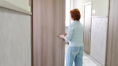 Woman closing the door to her office at the end of the workday. Everyday professional routine. High quality 4k footage
