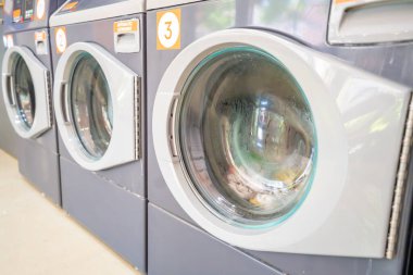 Çamaşır yıkama tesisinde sıra sıra çamaşır makineleri. Ev aletleri perspektife göre hizalandı. Yüksek kalite fotoğraf