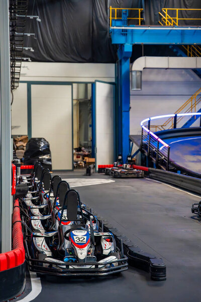 Prague, Czech Republic - September 21, 2025: Row of electric go-karts at CMKarting standing on charging stations. Sustainable motorsport, electric mobility and modern entertainment technology. 