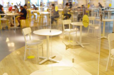 Cleary akrilik / plastik ayırıcı ya da müşterilerin güvenliğini sağlamak için yemek salonundaki masada duran bariyer. Covid-19 salgını sırasında yeni normal & sosyal uzaklık