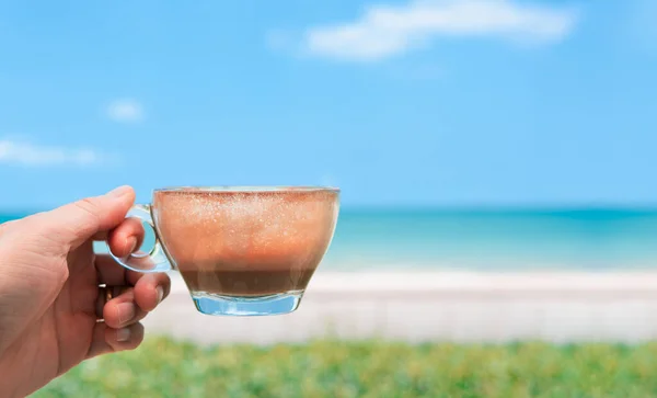 Rahatlatıcı tatil konsepti, el ele tutuşmalar güzel beyaz kumsala bir bardak kahve içmeler, sakin mavi gökyüzü ve güneşli sabahlarda önünde taze yeşil çalılar olan okyanus ufku..