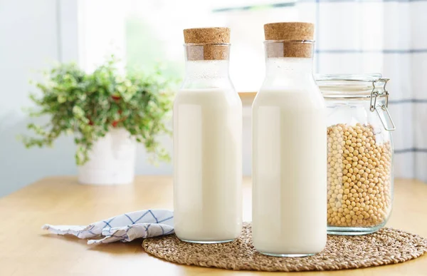 İki şişe taze ve ev yapımı soya sütlü soya fasulyesi dolu cam bir kavanoz. Alternatif sağlıklı süt, laktoz intolerans içeceği, vegan ve bitki temelli diyet konsepti. 