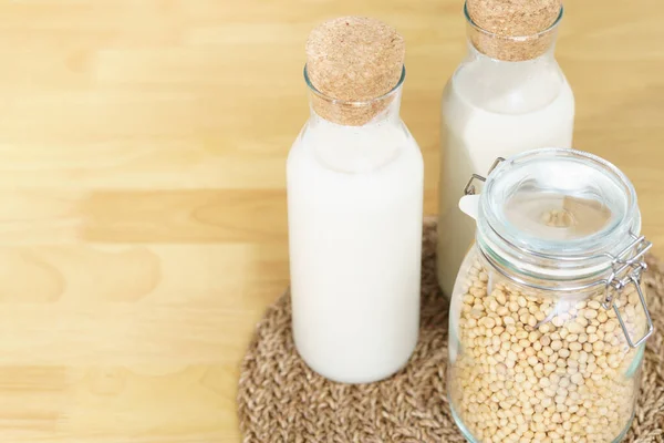 İki şişe taze ve ev yapımı soya sütlü soya fasulyesi dolu cam bir kavanoz. Alternatif sağlıklı süt, laktoz intolerans içeceği, vegan ve bitki temelli diyet konsepti. 