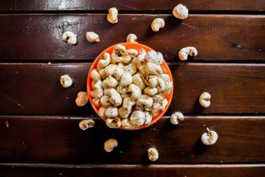 Tahta arka planda turuncu bir kasede patlamış mısır. Üst Manzara. Yatay Resim