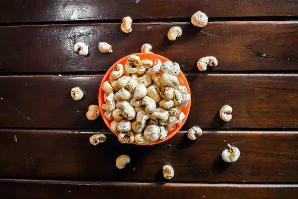 Popcorn in an orange bowl on wooden background. Top view. Horizontal Image