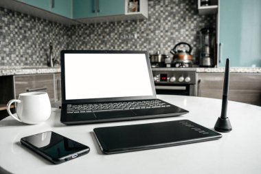 Evde, mutfakta bir mimarın işyeri. Masada dizüstü bilgisayar, grafik tableti ve telefon var. Uzaktan kumanda. Bağımsız