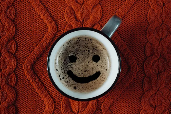 Cup of coffee with a smile on a knitted background — Stock Photo, Image