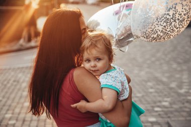  Annesinin kollarında küçük bir çocuk.