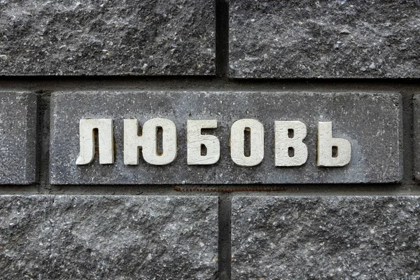 Die Inschrift an der grauen Ziegelwand in russischen Buchstaben "Liebe"" — Stockfoto