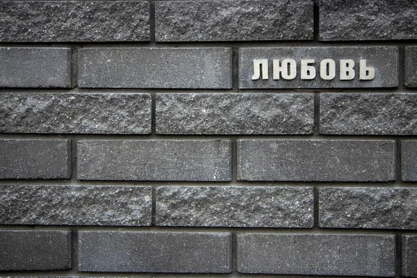 Ziegelsteinmauer mit russischer Inschrift "Liebe"" — Stockfoto