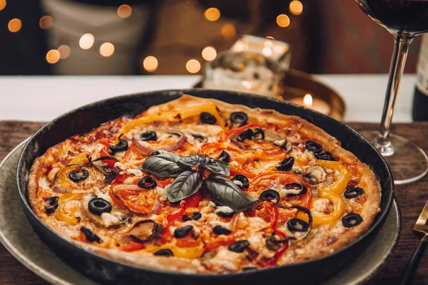 Pizza italiana calda per cena con un bicchiere di vino rosso. Serata romantica — Foto Stock