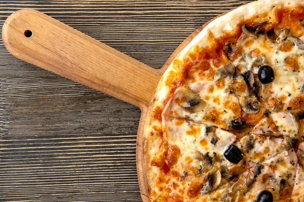 Pizza fresca italiana con funghi, olive e formaggio su un tavolo di legno — Foto Stock